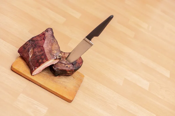 Viande fumée maison sur planche à découper en bois avec grand couteau — Photo