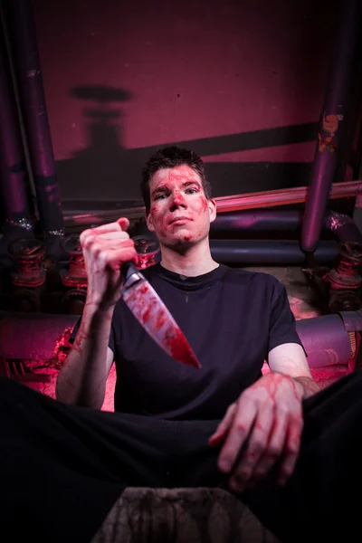 Horror killer con coltello in camera oscura con tubi e luce rossa — Foto Stock