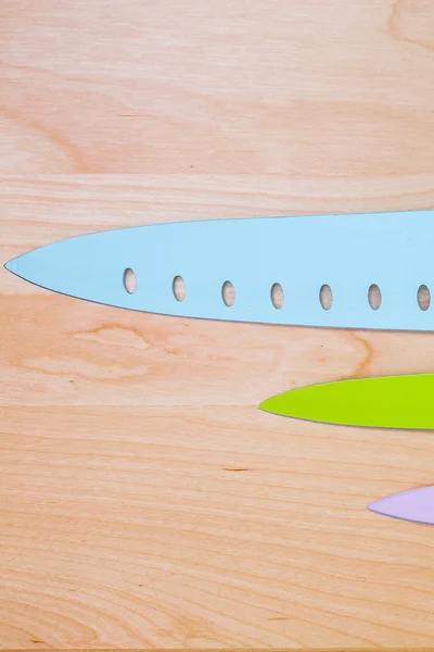 Vue de dessus sur couteau de couleur sur fond en bois avec copyspace — Photo