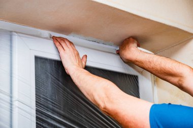 Odanın yenilenmesinden önce evdeki pencereler folyoyla korunuyor.