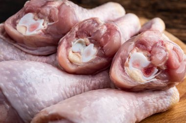 Tahtada çiğ tavuk budu, tahta arka planda..