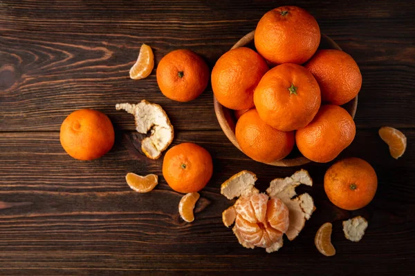 Mandarinky Oloupanými Plátky Tmavém Dřevěném Pozadí — Stock fotografie