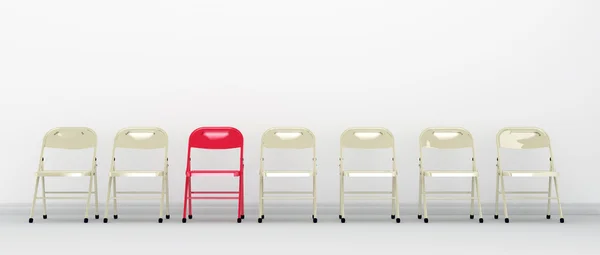 Een rode stoel staande in een rij van stoelen Stockfoto