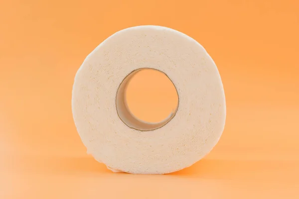 A roll of white toilet paper on an orange background. Material. Personal. Rest. Comfort. Closet. Recycled. Rolled. Single. Facilities. Resource. Utility. Object. Wc. Everyday. Sheet