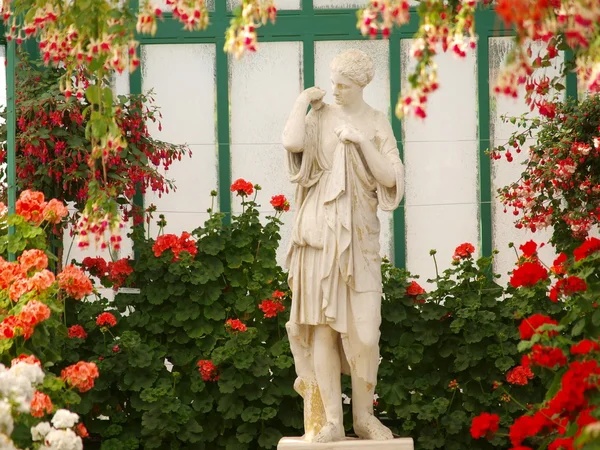 Flores e estátua feminina — Fotografia de Stock