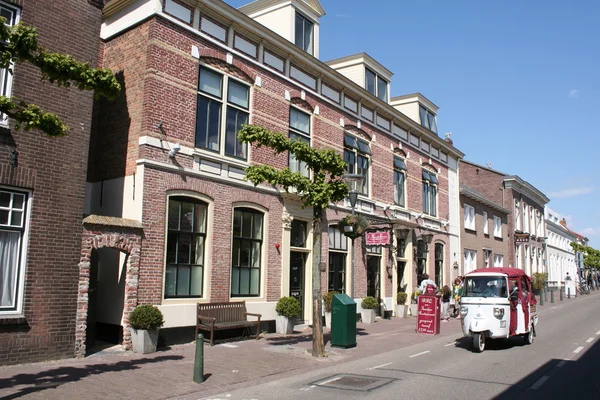 Régi házak és háromkerekű járművet az utcán in Middelburg — Stock Fotó