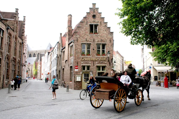 Carruagem de cavalos e casas antigas em Bruges — Fotografia de Stock