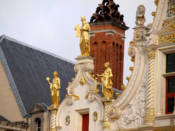 Dettagli sul tetto tre statue umane in oro, Bruges Immagine Stock