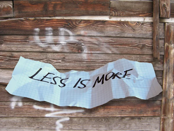 Palabra menos es más en papel desgarrado — Foto de Stock