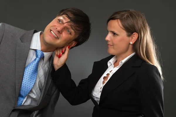 Geschäftsfrau zieht ein Geschäftsmann Ohr — Stockfoto