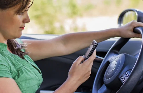 Woman driver reading a text message — Stock Photo, Image