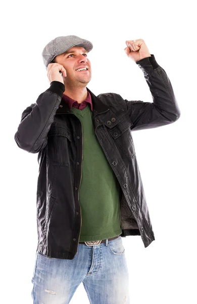 Happy young man with mobile phone receiving some great news — Stock Photo, Image