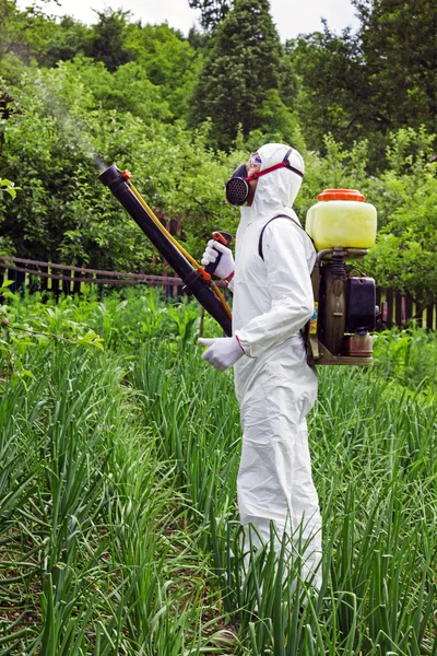 Hombre con ropa protectora completa rociando productos químicos — Foto de Stock