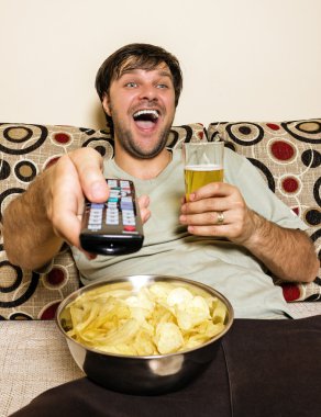 mutlu yemek patates cipsi ve DRI, televizyon, genç adam