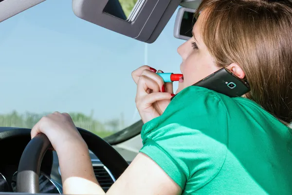 Jonge vrouw rijden, toepassing van lippenstift en spreken op haar smar — Stockfoto