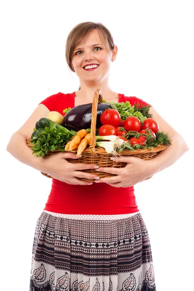 Ευτυχισμένη νέα γυναίκα που κρατά το καλάθι με λαχανικά — Φωτογραφία Αρχείου