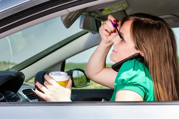 Mujer bastante joven aplicando maquillaje, hablando por teléfono y bebiendo — Foto de Stock