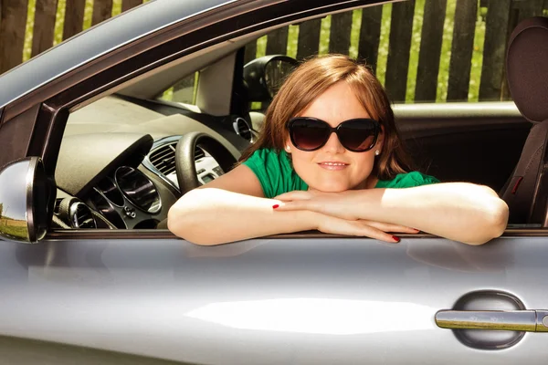 Close-up van een mooie jonge vrouw in haar nieuwe auto — Stockfoto