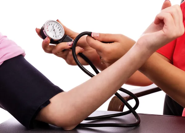 Médico tomando jovem mulher pressão arterial — Fotografia de Stock