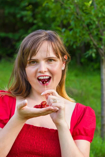 Sweet woman eating cherries — Stock Photo, Image