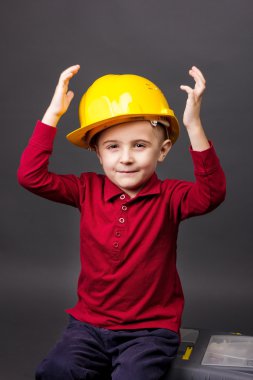 toolbox üzerinde oturan kask ile sevimli küçük çocuk