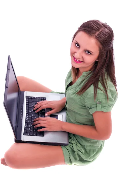 Νεαρή γυναίκα που κάθεται στο πάτωμα με ένα φορητό υπολογιστή — Φωτογραφία Αρχείου