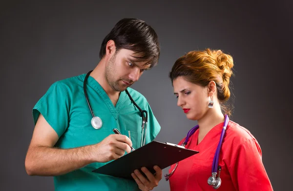 Two fellow doctors discussing and looking surprised at something — Stock Photo, Image