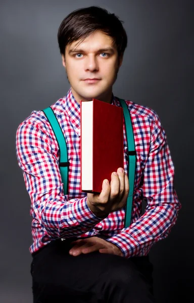 Portrait of a handsome young man holding a book — Stock Photo, Image