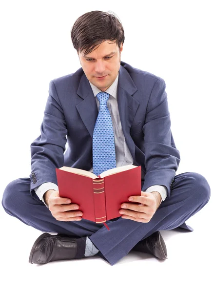 Hombre de negocios sentado con las piernas cruzadas y leyendo — Foto de Stock