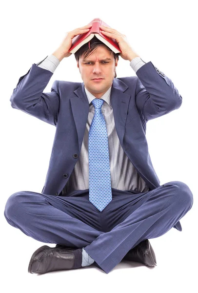 Young businessman covering his head with an open book — Stock Photo, Image