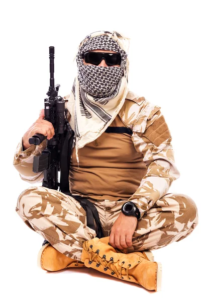 Soldier in camouflage and arabian scarf holding a rifle — Stock Photo, Image