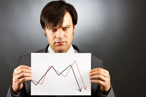 Uomo d'affari arrabbiato che mostra un grafico in calo del mercato azionario — Foto Stock
