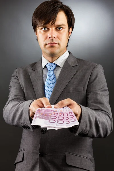 Young businessman showing euro banknotes — Stock Photo, Image