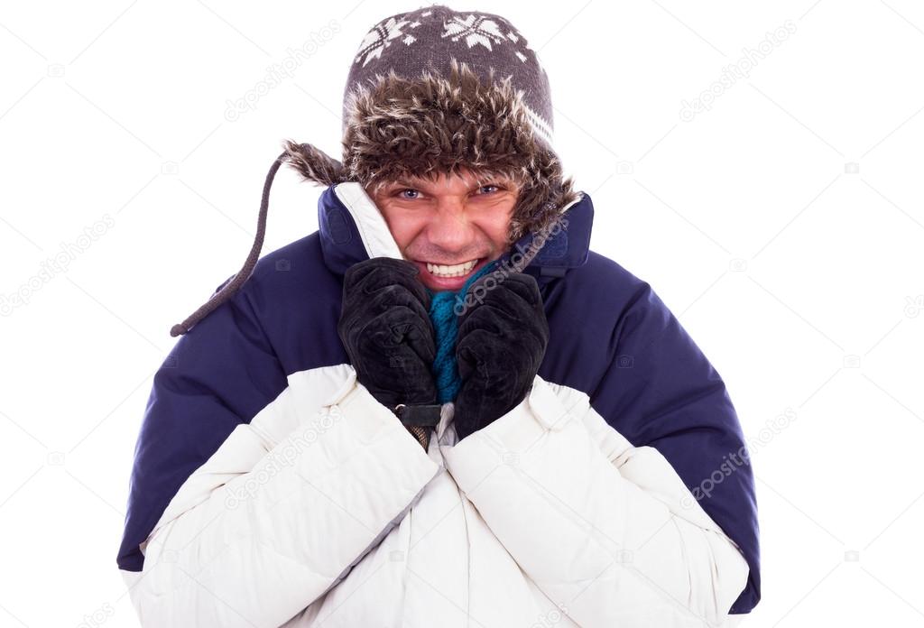 Young man with hat and coat shivering from cold