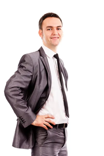 Улыбающийся молодой бизнесмен с руками на бедрах — стоковое фото