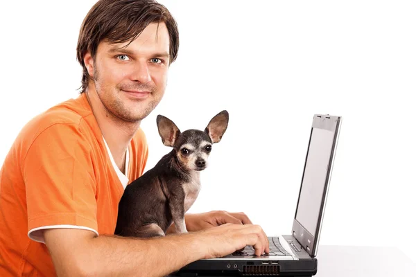 Улыбающийся молодой человек, сидящий со своей милой чихуахуа-собакой впереди — стоковое фото