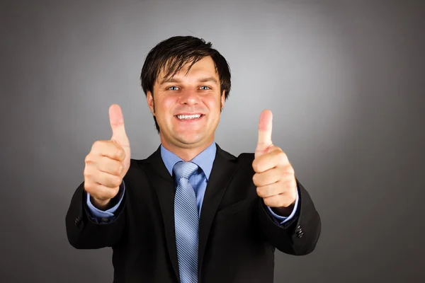 Šťastný mladý obchodní muž ukazuje palec nahoru gesto — Stock fotografie