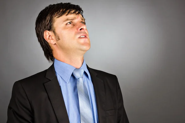 Retrato de close-up de um jovem empresário irritado olhando para cima — Fotografia de Stock