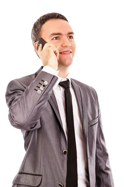 Happy young businessman talking at the phone and looking up — Stock Photo, Image