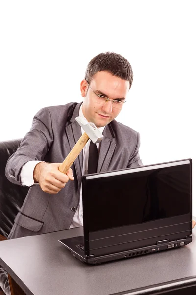 Young businessman with a hammer ready to smash his laptop while — Stock Photo, Image