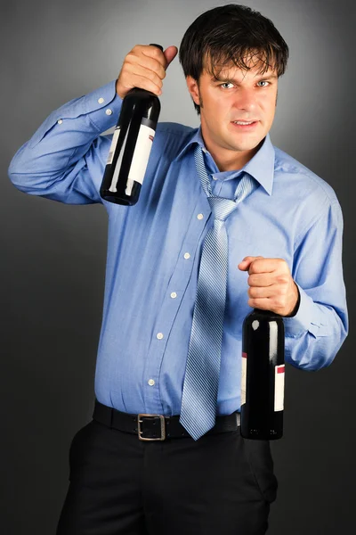 Portrait of a drunk businessman holding two bottles — Stock Photo, Image