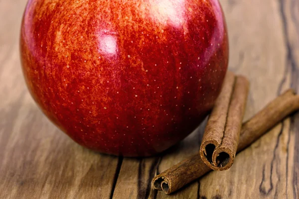 Červené jablko se skořicí hole — Stock fotografie