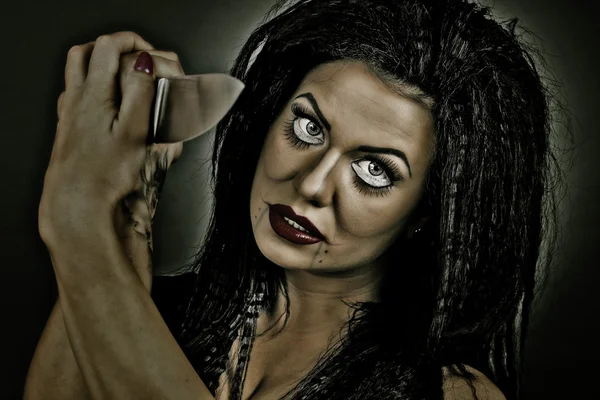 Brünette junge Frau mit kreativem Make-up und einem großen Messer — Stockfoto