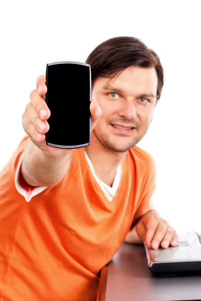 Jovem mostrando seu telefone inteligente enquanto sentado na mesa — Fotografia de Stock