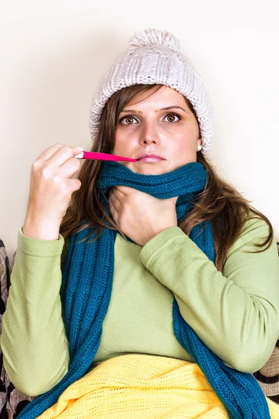 Junge Frau nimmt ihre Temperatur — Stockfoto