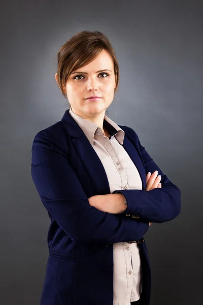 Portrait of young business woman standing with arms crossed — Stock Photo, Image