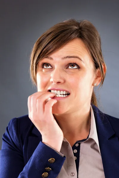 Closeup portrait of a nervous young businesswoman biting her fin — Stock Photo, Image