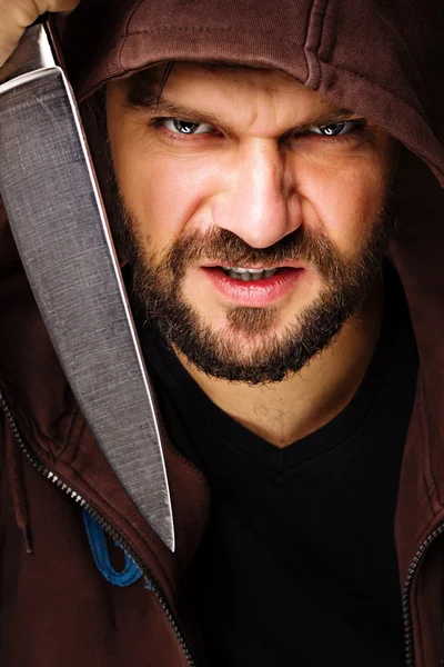 Closeup portrait of a threatening man with beard holding a knife — Stock Photo, Image