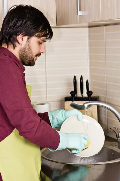 Молодий чоловік миє посуд — стокове фото