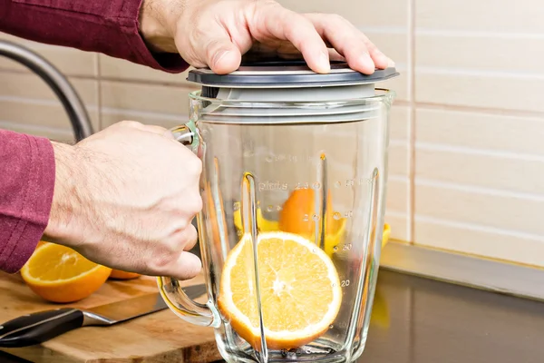 Primer plano de un hombre preparando jugo de naranja — Foto de Stock